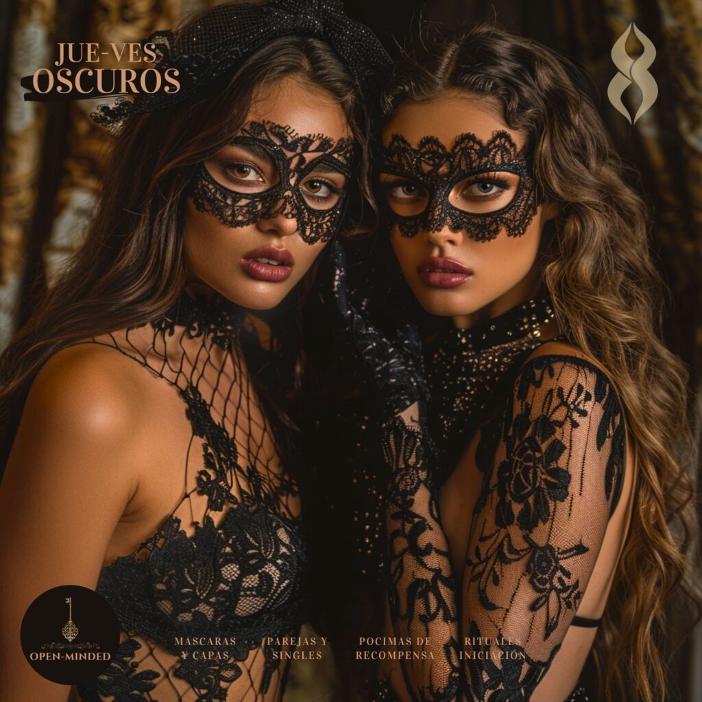 Dos mujeres enmascaradas, con lencería negra y capas, abrazándose en un ambiente oscuro y sensual.